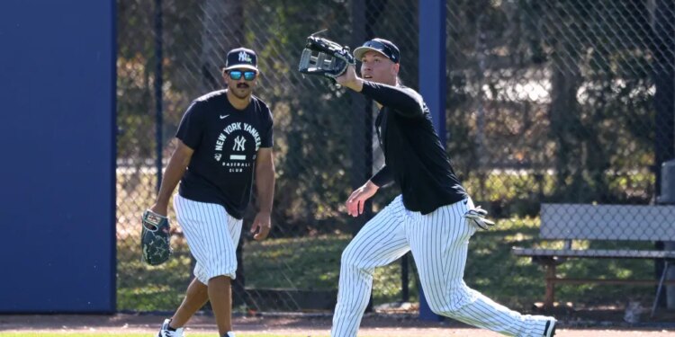 New York Yankees right fielder Aaron Judge catches a ball in front of center fielder Trent Grisham during spring training.