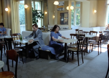 Sam Neill and Isabelle Adjani seated in a cafe facing away from each other in 1981’s Possession.