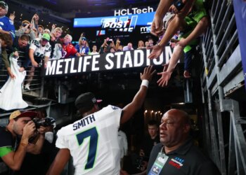 Seattle Seahawks quarterback Geno Smith (7) high-fives fans after the game at MetLife Stadium.