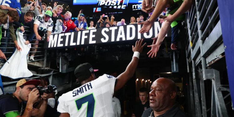 Seattle Seahawks quarterback Geno Smith (7) high-fives fans after the game at MetLife Stadium.