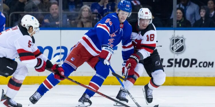 New York Rangers center Adam Edstrom (84) and New Jersey Devils left wing Ondrej Palat (18) fight for possession of the puck.