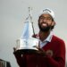 Akshay Bhatia smiles as he holds up the Arnold Palmer Invitational golf trophy.