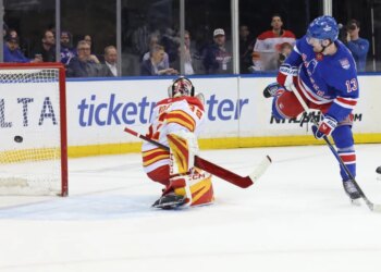 Alexis Lafrenière tips a puck past Dustin Wolf for the first of his three goals in the Rangers' 4-0 win over the Flames at the Garden on March 10, 2026.
