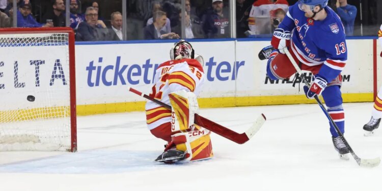 Alexis Lafrenière tips a puck past Dustin Wolf for the first of his three goals in the Rangers' 4-0 win over the Flames at the Garden on March 10, 2026.
