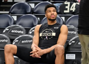 Giannis Antetokounmpo watching the warmup session from the bench.