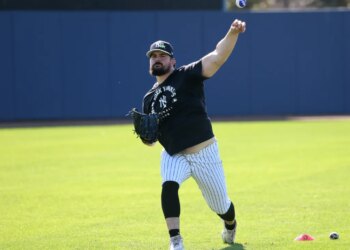 New York Yankees pitcher Carlos Rodón #55, throwing a multi-colored ball in the outfield during practice at Steinbrenner Field, the Yankees Spring Training home in Tampa, Florida.