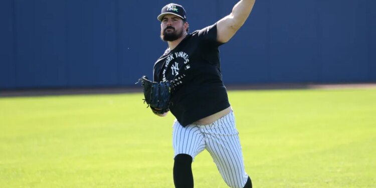 New York Yankees pitcher Carlos Rodón #55, throwing a multi-colored ball in the outfield during practice at Steinbrenner Field, the Yankees Spring Training home in Tampa, Florida.