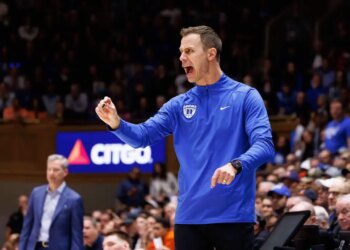 Duke head coach Jon Scheyer shouts towards the court during a college basketball game.