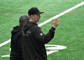 Jets general manager Darren Mougey talking to coach Aaron Glenn on the practice field.