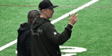 Jets general manager Darren Mougey talking to coach Aaron Glenn on the practice field.