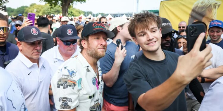 A young man taking a selfie with David Portnoy at the One Bite Pizza Festival.