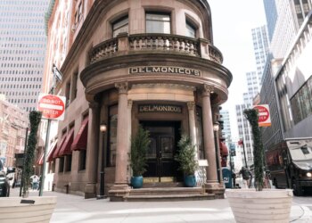Delmonico's restaurant and steakhouse, a historic building with large ornate columns, located on a street corner in New York City.