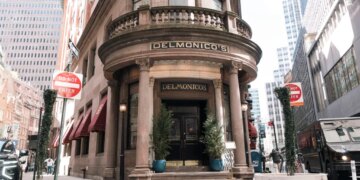 Delmonico's restaurant and steakhouse, a historic building with large ornate columns, located on a street corner in New York City.