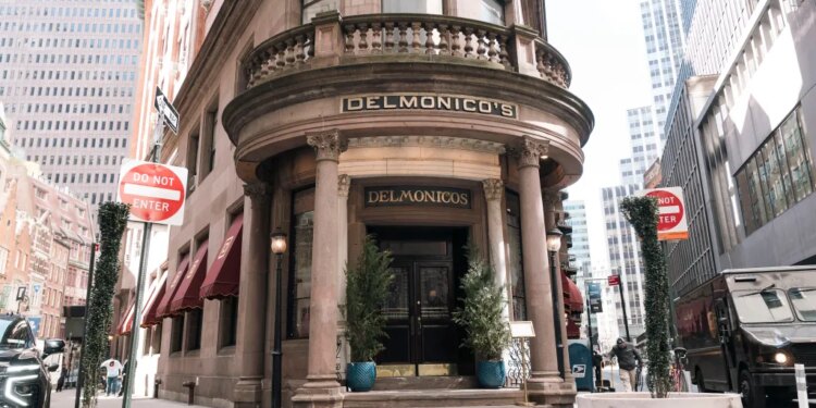 Delmonico's restaurant and steakhouse, a historic building with large ornate columns, located on a street corner in New York City.