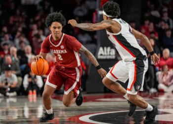 Tide guard Aden Holloway (2) dribbles against Georgia Bulldogs guard Marcus Millender (4) at Stegeman Coliseum.