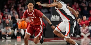 Tide guard Aden Holloway (2) dribbles against Georgia Bulldogs guard Marcus Millender (4) at Stegeman Coliseum.