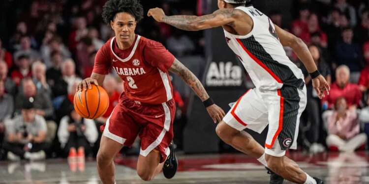 Tide guard Aden Holloway (2) dribbles against Georgia Bulldogs guard Marcus Millender (4) at Stegeman Coliseum.