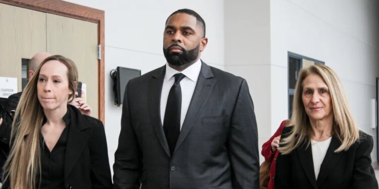 Former Michigan football coach Sherrone Moore with his wife, Kelli Moore, and attorney Ellen Michaels, arriving for a court hearing.