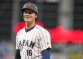 Shohei Ohtani smiling in his Japan baseball uniform during a World Baseball Classic game.