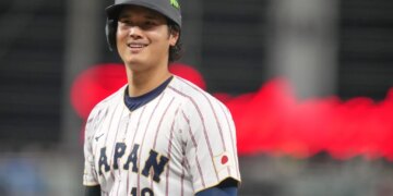 Shohei Ohtani smiling in his Japan baseball uniform during a World Baseball Classic game.