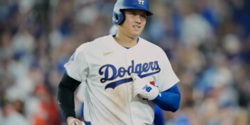 Shohei Ohtani in a Los Angeles Dodgers uniform and helmet on the field.