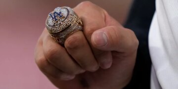 A close-up of Shohei Ohtani's hand holding a Los Angeles Dodgers World Series ring.