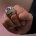 A close-up of Shohei Ohtani's hand holding a Los Angeles Dodgers World Series ring.