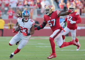 Gary Brightwell of the New York Giants runs the ball as Dre Greenlaw of the San Francisco 49ers gives chase.