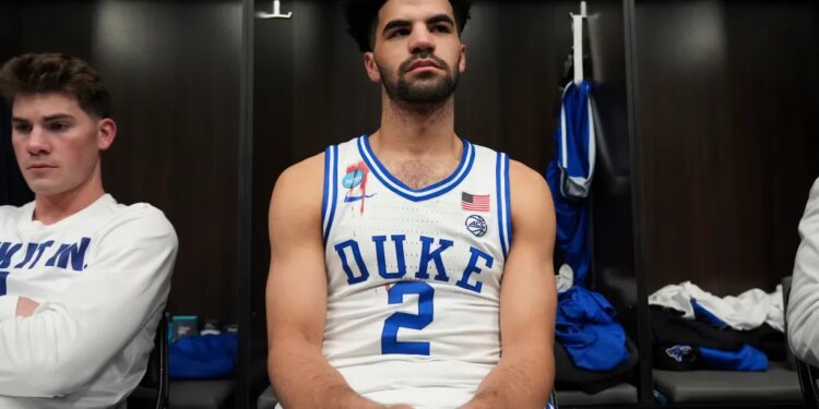 Duke guard Cayden Boozer sits in the locker room after their Elite Eight game.