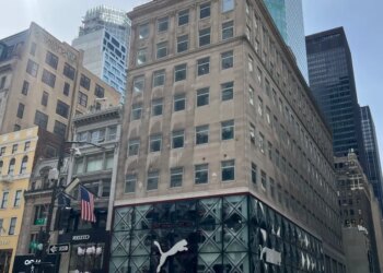 The 609 Fifth Ave building, with a Puma store on the ground floor, on a busy New York City street.