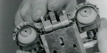 A photo of a hand holding the mechanical eyes of humanoid machine.