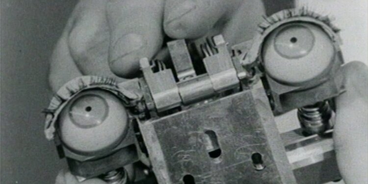 A photo of a hand holding the mechanical eyes of humanoid machine.