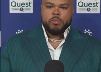 Jermaine Eluemunor sports a snazzy suit while speaking to the media.