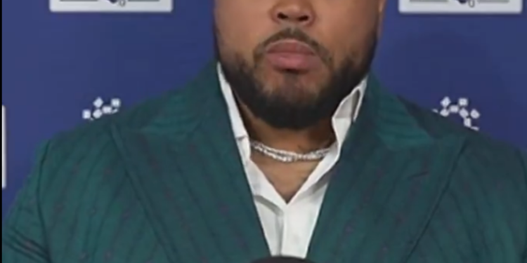 Jermaine Eluemunor sports a snazzy suit while speaking to the media.