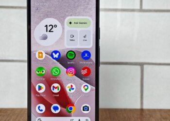 Photo of Google Pixel 10A in front of white tiles, showing the home screen