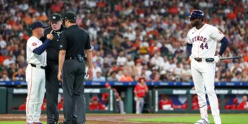 Houston Astros manager Joe Espada argues with home plate umpire Chris Conroy while designated hitter Yordan Alvarez looks on.