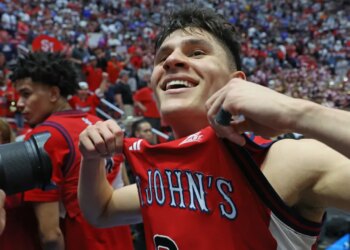 St. John's Red Storm guard Dylan Darling holding his jersey up after winning the game.