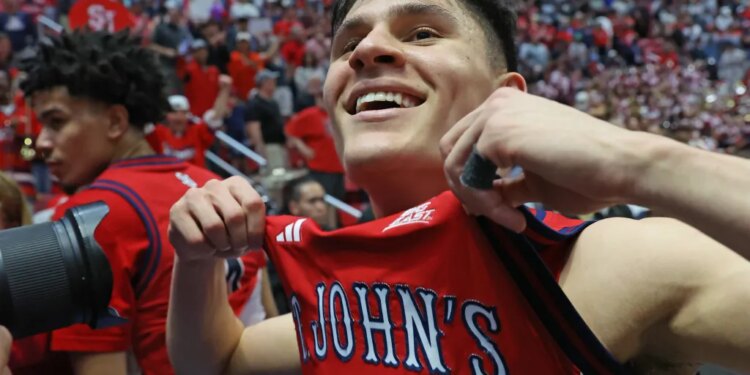 St. John's Red Storm guard Dylan Darling holding his jersey up after winning the game.