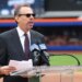 A man in a pinstripe suit and sunglasses speaks at a podium with "Citi Field" branded microphones.