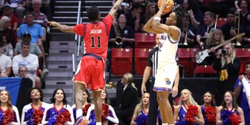 St. John's Red Storm player Ian Jackson jumps to block a shot by Kansas Jayhawks player Darryn Peterson during the NCAA Tournament.