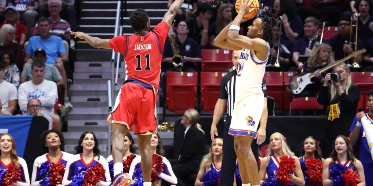 St. John's Red Storm player Ian Jackson jumps to block a shot by Kansas Jayhawks player Darryn Peterson during the NCAA Tournament.