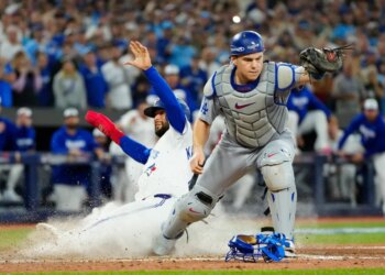 Blue Jays runner Isiah Kiner-Falefa sliding into home plate as Dodgers catcher Will Smith reaches for the ball.