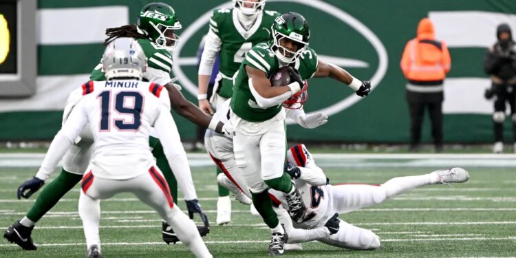 Jets running back Kene Nwangwu (34) breaks away from Patriots safety Dell Pettus (24).