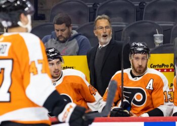 Philadelphia Flyers head coach John Tortorella speaks to his players on the bench.