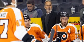 Philadelphia Flyers head coach John Tortorella speaks to his players on the bench.
