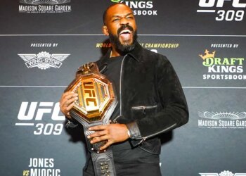 UFC Heavyweight Champion Jon Jones holding his championship belt.