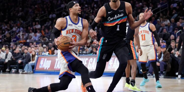 New York Knicks guard Josh Hart drives to the basket as San Antonio Spurs forward Victor Wembanyama gives chase.