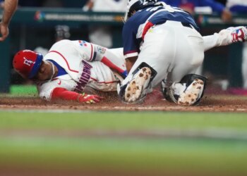 Juan Soto slides across home plate to score, while the South Korea catcher is on his knees behind him.