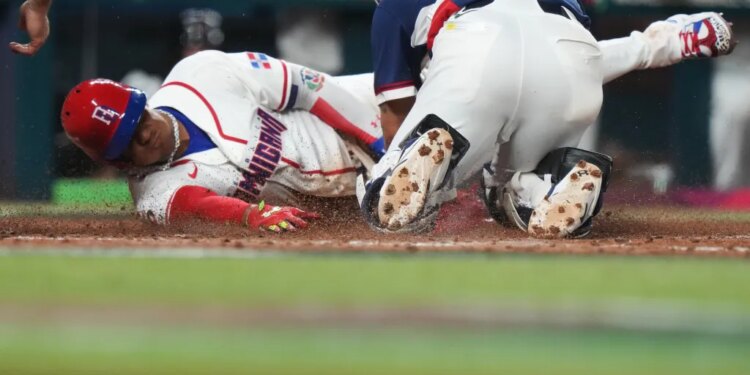Juan Soto slides across home plate to score, while the South Korea catcher is on his knees behind him.