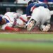 Juan Soto slides across home plate to score, while the South Korea catcher is on his knees behind him.